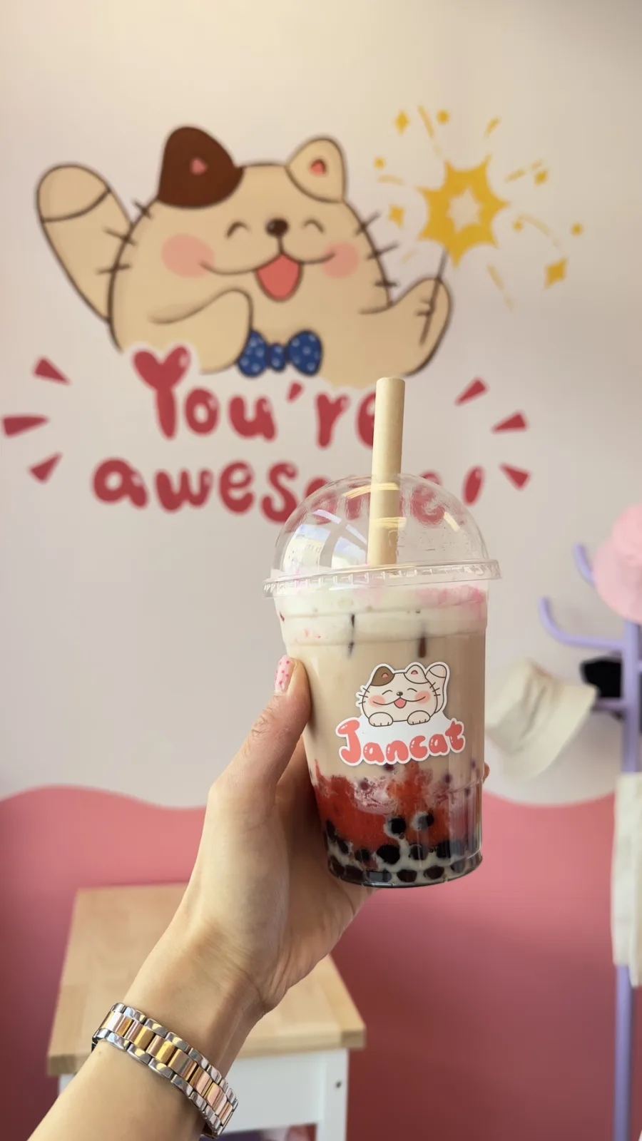 Bubble tea in front of Jancat's 'you're awesome' artwork